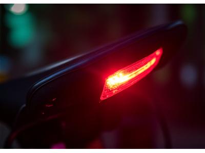 Compact, bright red bicycle tail light blinking in the dark